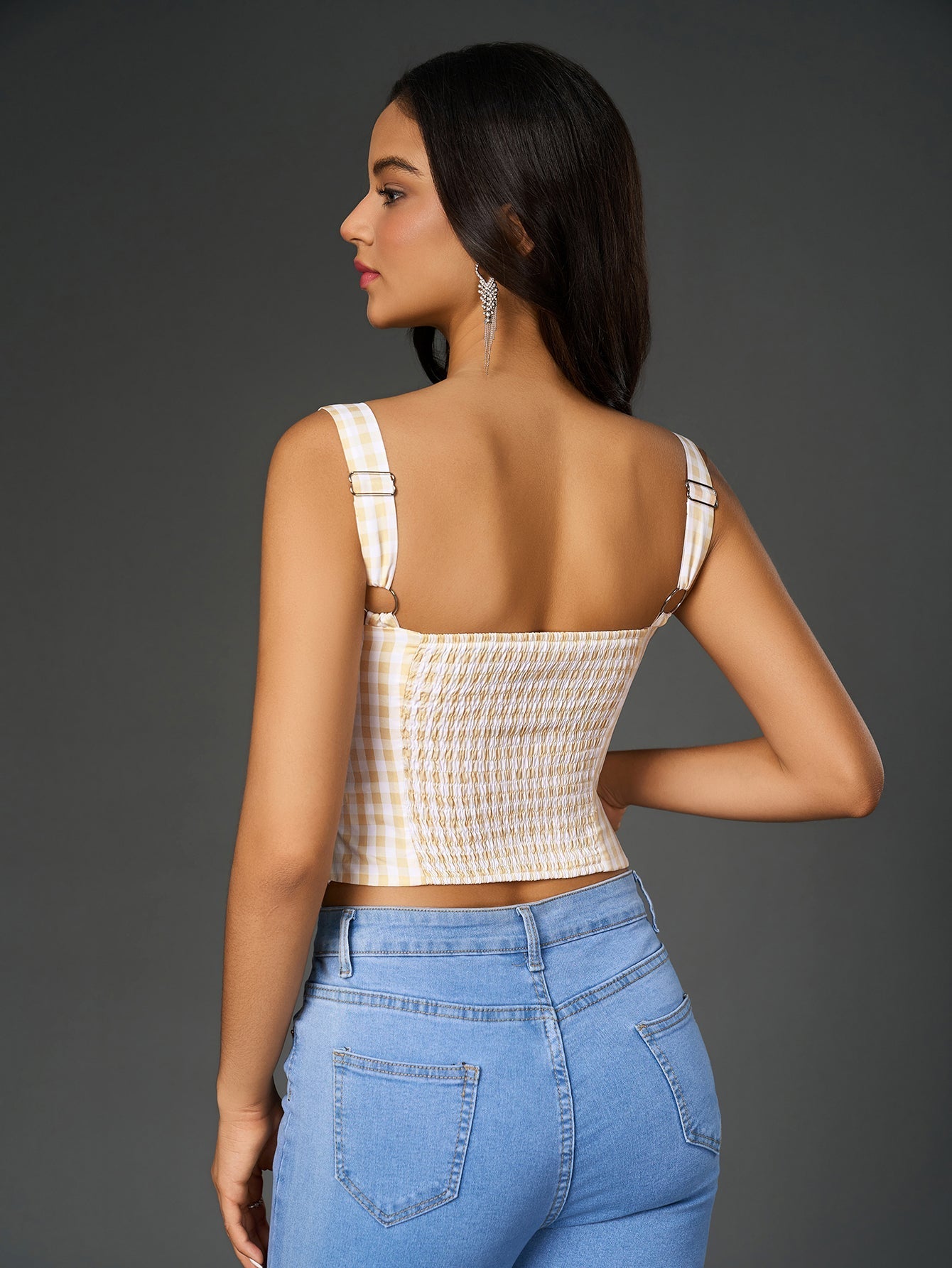 Back view of a woman in a plaid print crop top with smocked detailing and adjustable straps