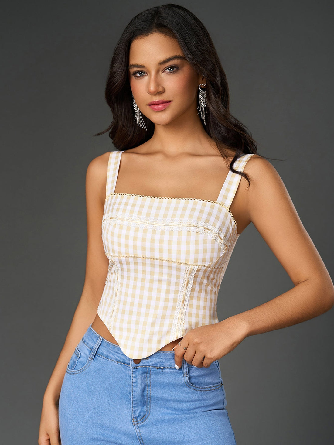 Woman wearing a yellow and white plaid print embellished crop top with wide straps and an asymmetrical hem