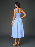 Back view of a woman in a blue plaid midi dress with a flared skirt.