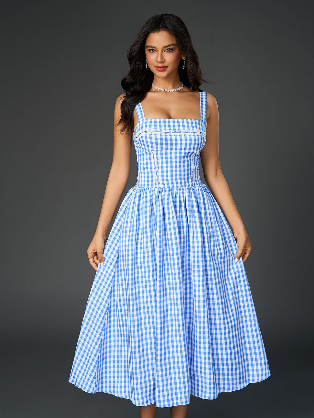 Full-length shot of a woman in a blue plaid midi dress with white bow heels.