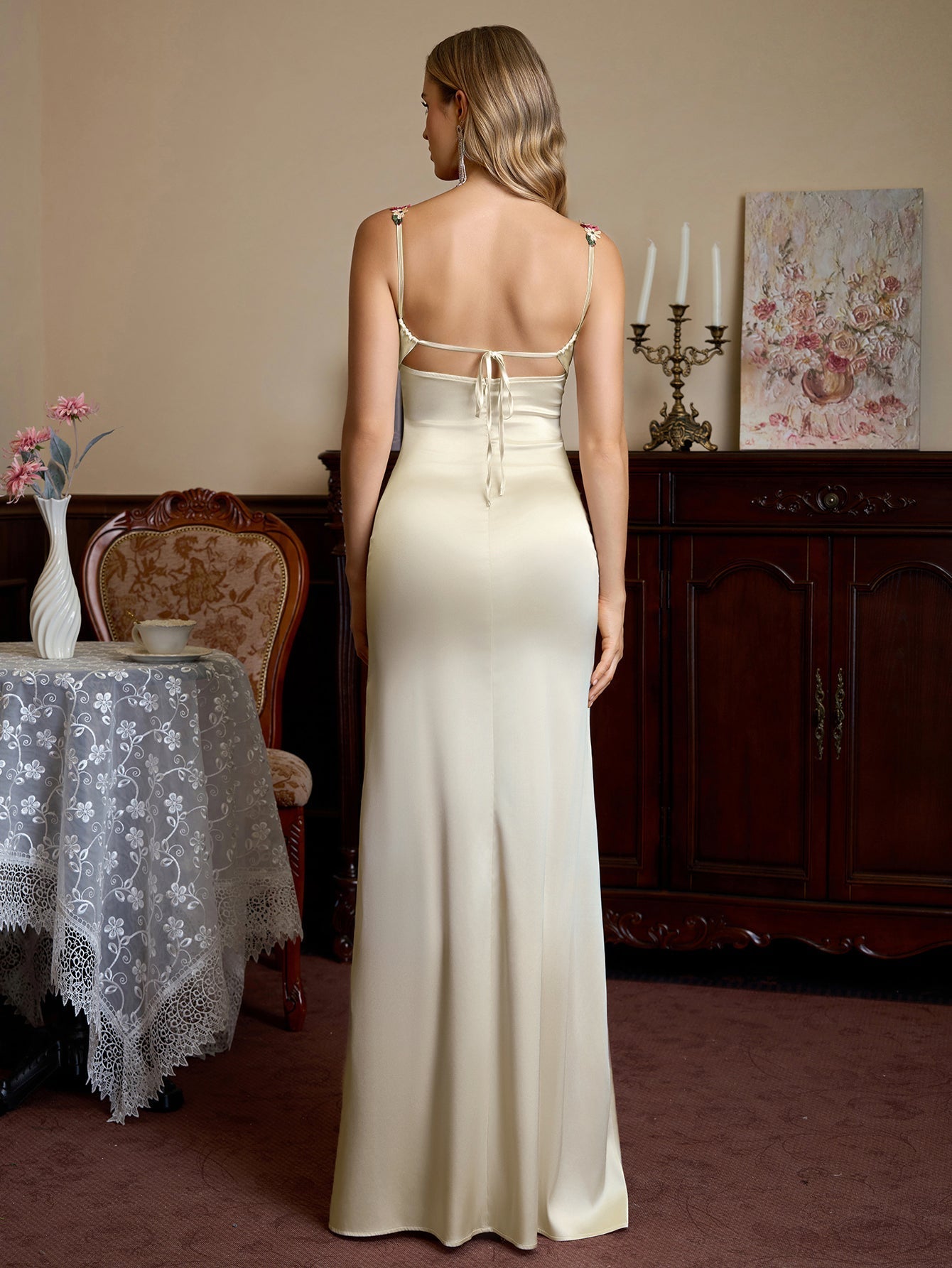 Back view of a cream satin evening gown with a tie-back closure and thin straps