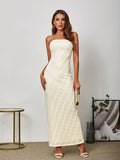 Full body view of a woman in a beige lace strapless maxi dress