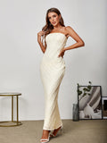 Close-up of a woman wearing a beige lace strapless maxi dress