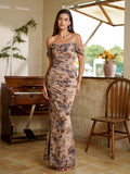Woman in a long, ruched, off-the-shoulder dress with a floral print, looking at the camera.