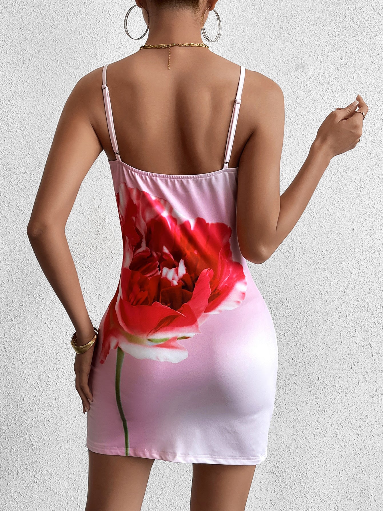 back view of a woman in a pink bodycon dress with a poppy print