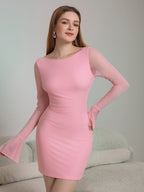 Woman in a pink short dress with sheer bell sleeves and a boat neck.