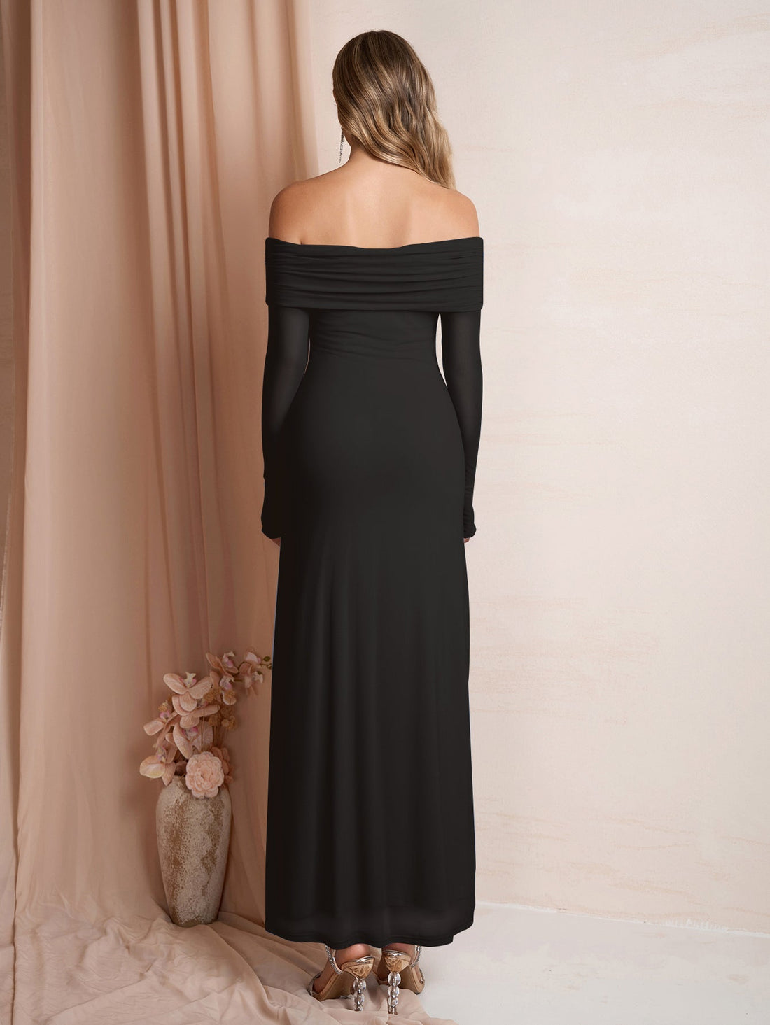 Woman wearing a black off-the-shoulder maxi dress with long sleeves.