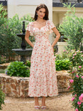 Model showcasing a white floral print midi dress with a tiered hemline.