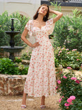 Woman wearing a white floral print midi dress with flutter sleeves and a tiered skirt.