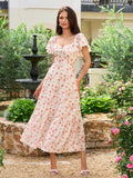 Woman in a white floral print midi dress with ruffled sleeves and a sweetheart neckline.