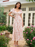Full length shot of a woman in a white floral print midi dress posing outdoors.
