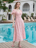 Woman in a pink textured midi dress with puff sleeves and a thigh-high slit, posing by a pool.