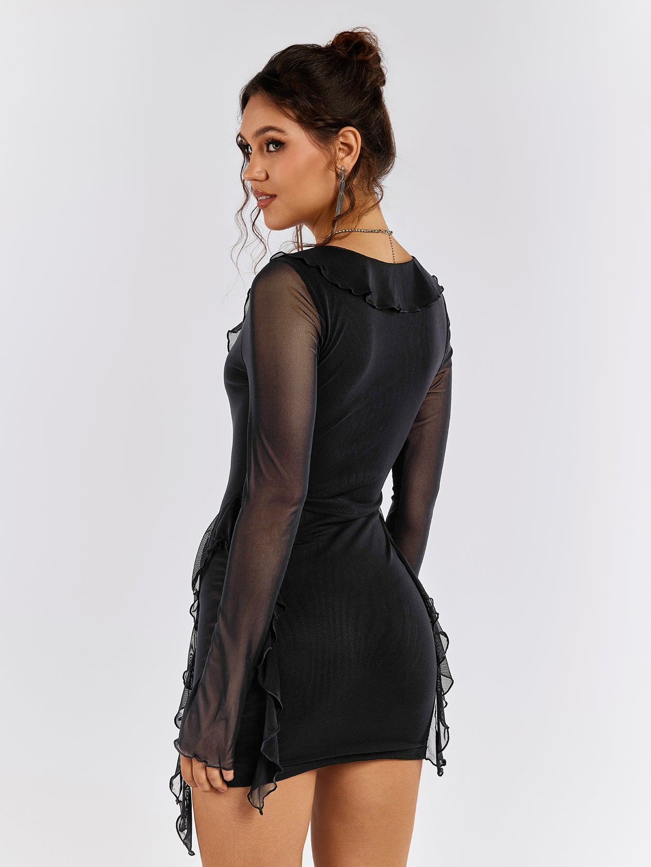 Back view of a woman in a black sheer mesh dress with ruffle trim