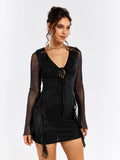 Front three-quarter view of a woman in a black sheer mesh mini dress