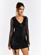 Front three-quarter view of a woman in a black sheer mesh mini dress