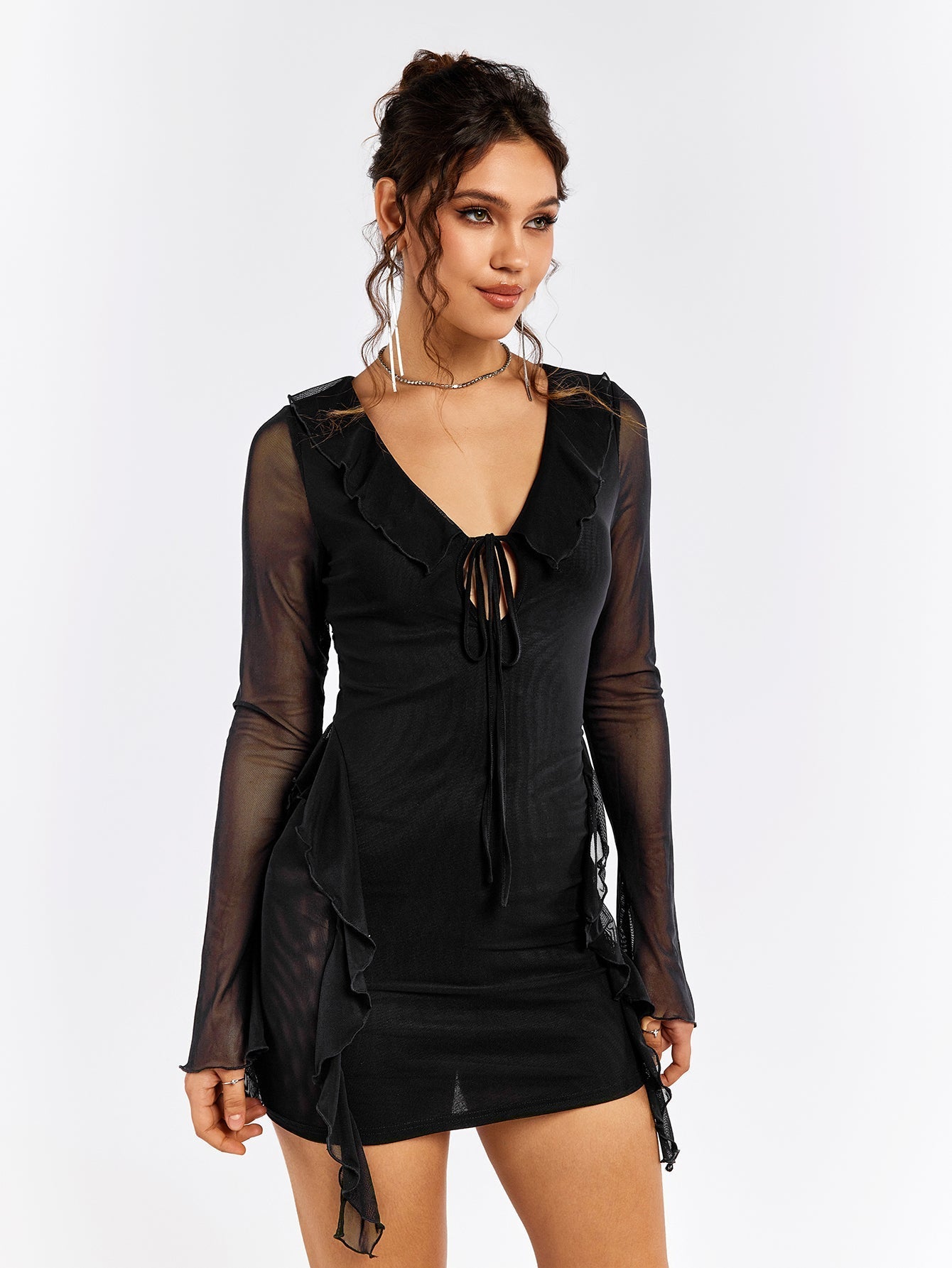 Front three-quarter view of a woman in a black sheer mesh mini dress