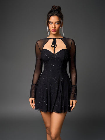 Woman in a black sparkly mesh dress with long bell sleeves and a keyhole neckline
