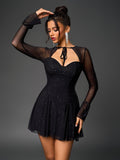 Woman posing in a black sparkly mesh dress, touching her hair
