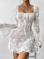 Woman wearing a white lace mini dress with long bell sleeves and a square neckline
