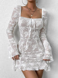 Close-up of a woman in a white lace mini dress showcasing the tie-front detail