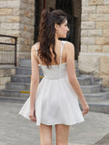 Back view of a woman in a white sleeveless fit and flare day dress with a smocked back panel