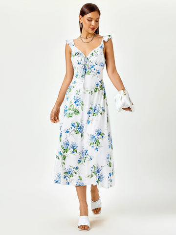 Woman wearing a white midi dress with a blue floral print, featuring ruffled straps and a tie-front detail.