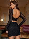 Rear view of a woman in a black sparkly sheer mesh long-sleeve crop top with an open back and zipper closure, paired with a black sparkly sheer mesh mini skirt.