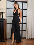 Side profile of a woman in a black halter neck formal dress showcasing the flowing mermaid skirt.