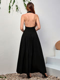 Back view of a woman in a black halter neck maxi dress with an open back.