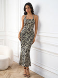 Full body shot of a woman in a black and beige floral print halter neck maxi dress