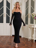 Woman wearing a black glitter mermaid gown with detached sheer sleeves