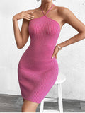 Side profile of a woman in a pink metallic knit bodycon halter dress