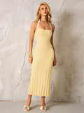 Woman wearing a yellow ribbed knit halter midi dress from the front.