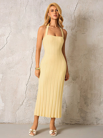 Woman wearing a yellow ribbed knit halter midi dress from the front.