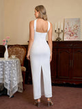 Back view of a woman in a white strapless column maxi dress with a high leg slit.