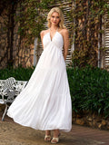 Woman wearing a white halter maxi dress with a tiered skirt in an outdoor setting.