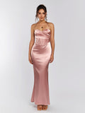 Front view of a woman wearing a pink satin halter neck mermaid gown with a corset detail