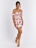 Woman standing in a white floral print mini dress, showcasing the off-the-shoulder sleeves and halter neckline.