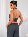 Back view of a woman wearing a brown halter neck cropped vest.