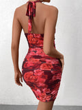 Back view of a woman wearing a red floral print halter neck bodycon mini dress with ruched detailing.