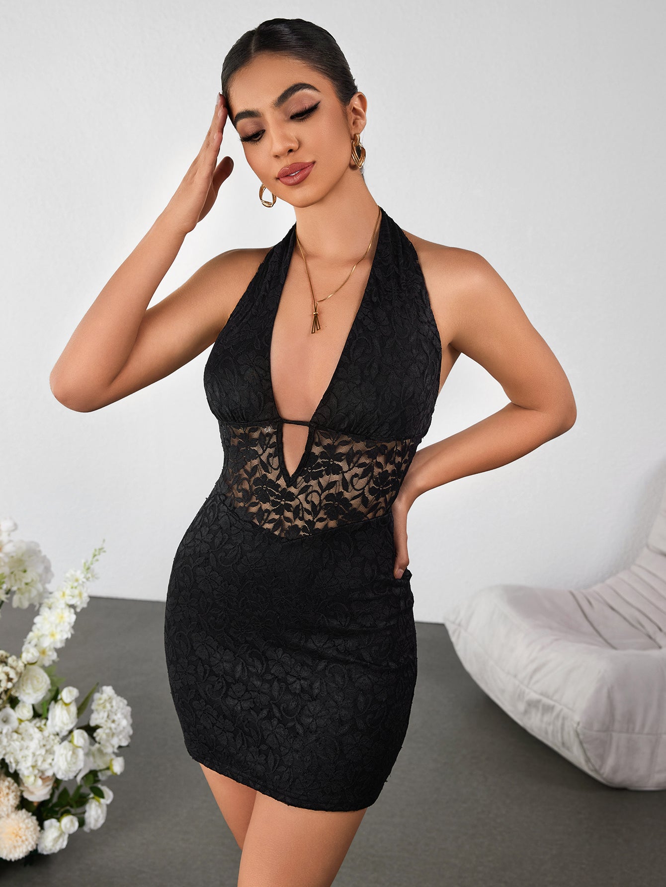 Woman posing in a black lace halter dress
