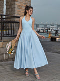 Woman holding a bouquet of flowers while wearing a light blue halter neck midi dress