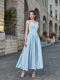 Front three-quarter view of a woman in a light blue halter neck midi dress