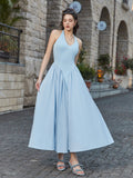 Woman showcasing the flowy skirt of a light blue halter neck midi dress