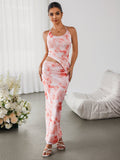 Woman wearing a pink and white tie-dye maxi dress with a halter neckline and asymmetrical hem