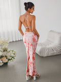 Woman from the back in a pink tie-dye halter maxi dress with a high slit