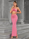 Woman looking over her shoulder in a pink halter neck two-piece evening gown