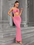Woman posing in a pink halter neck two-piece evening gown with floral detail