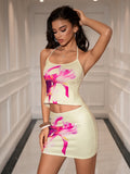 Woman posing in a yellow floral print halter neck crop top and matching mini skirt