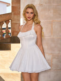 model posing in a white mini dress with a halter neckline and flared skirt